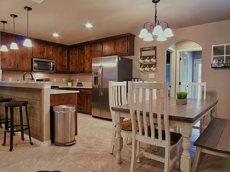 The kitchen offers stainless steel appliances, a breakfast bar with seating for 3, and a refrigerator that stays with the home.