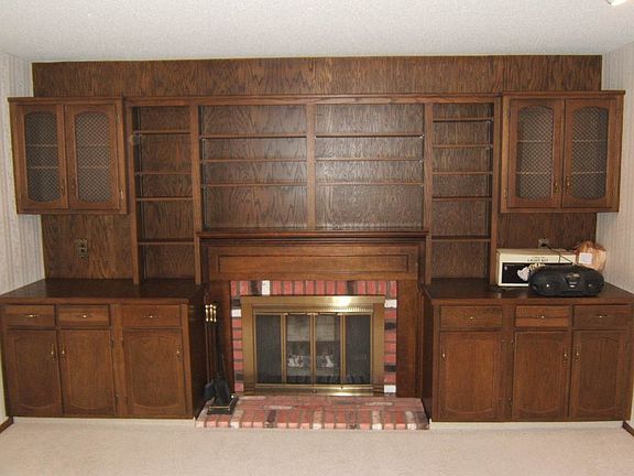 The living room has a wood burning fireplace with beautiful built in wood shelves and storage all around it.