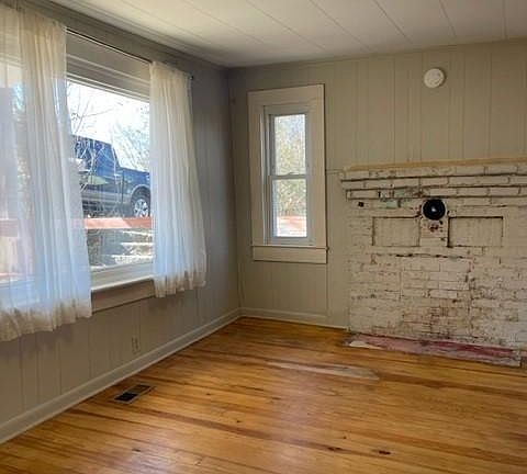 Livingroom has large windows and natural light.