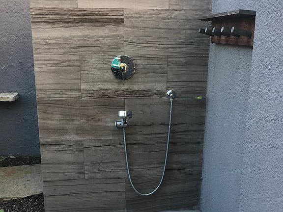 Two separate outdoor showers for use after pool or surfing a