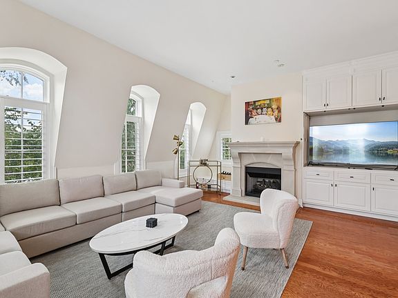 Living room with built-in media cabinet, fireplace, and abundant natural light.