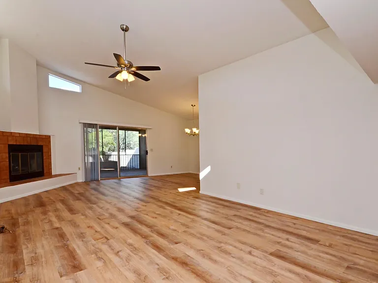 Light and bright living room with high ceilings, fireplace and view to private back patio!