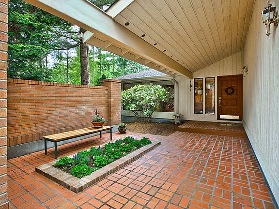 Covered brick courtyard greet your guest as they enter your home. Custom built in planter adds charm