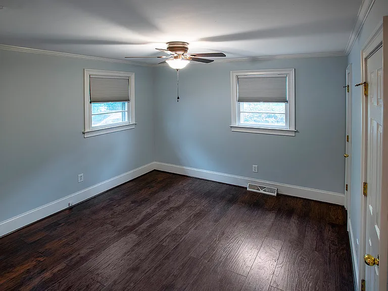 Take a couple of steps down into this sweet front bedroom, equipped with blackout shades, a small closet, and a full bathroom.