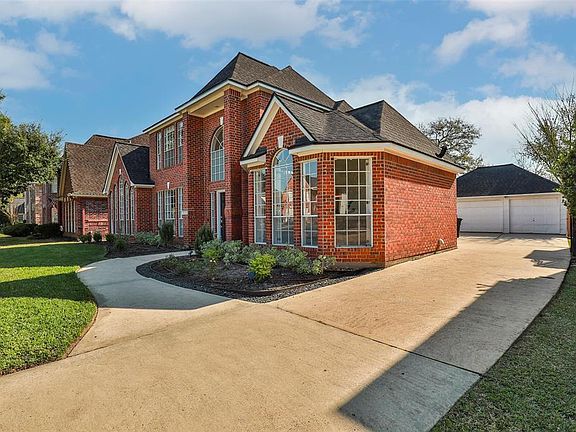 The long driveway leads to a detached 3-car garage