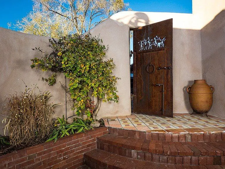 Exit to your reserved parking space; iron gate is designed by a famous iron smith artist in the 1980's. Complete privacy and high 6 foot wall to keep your pets in!