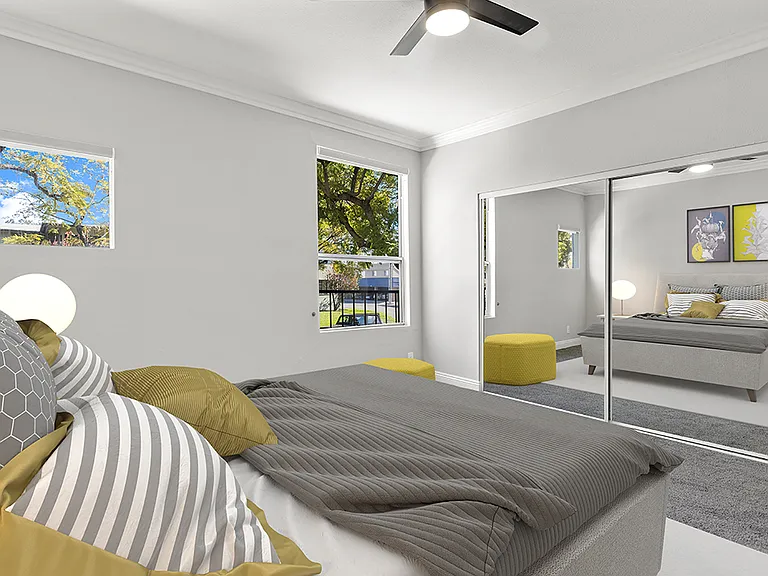 Carpeted bedroom with ceiling fan.