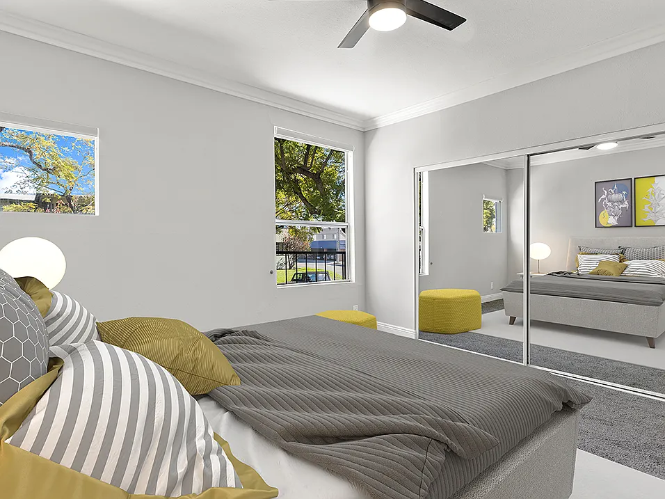 Carpeted bedroom with ceiling fan.
