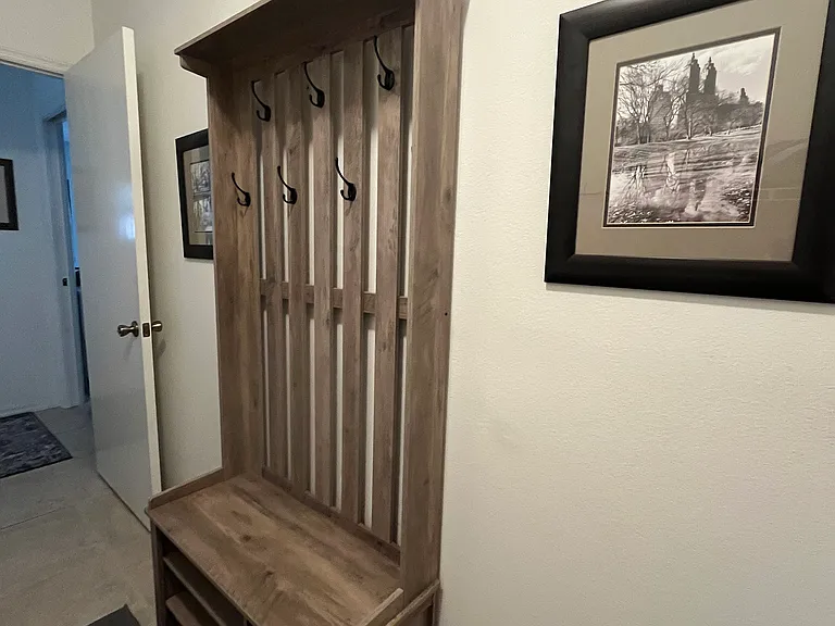 Hall tree in laundry room provides coat, bags and extra shoe storage