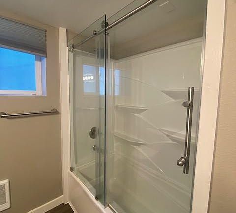Primary bathroom tub with sliding door