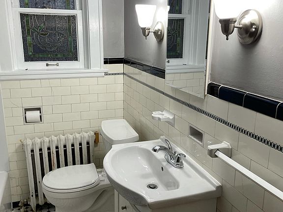 Bathroom has updated sink and fixtures, new toilet, and tub surround.