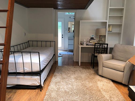 View into large bathroom with large closet and door to private outdoor deck.