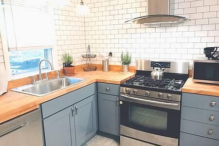 fully stocked modern kitchen with stainless steel appliances. dishwasher, microwave