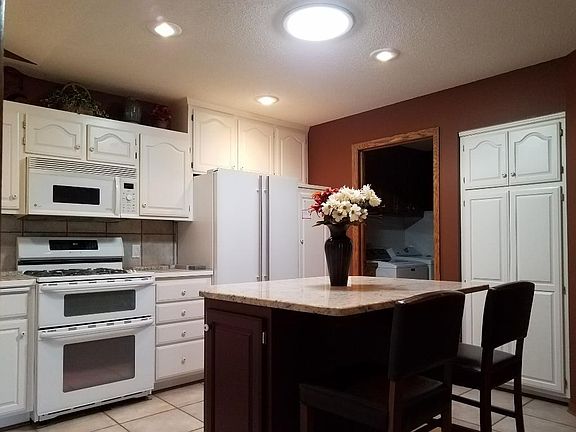 The central kitchen is complete with a granite center island with storage, a breakfast bar, roll out cabinets, designer appliances, double dutch oven and connected to the mud room full of perks.