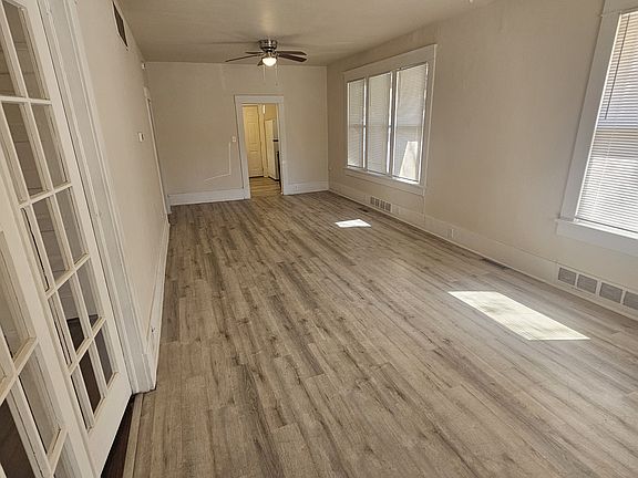 Walking in the front door. Big living room with high ceilings and natural light. Kitchen in back. Bedroom or dining room with French doors to the left.