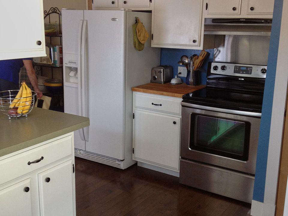 Glass-top stainless range and butcher-block prep counter. Side-by-side refrigerator.
