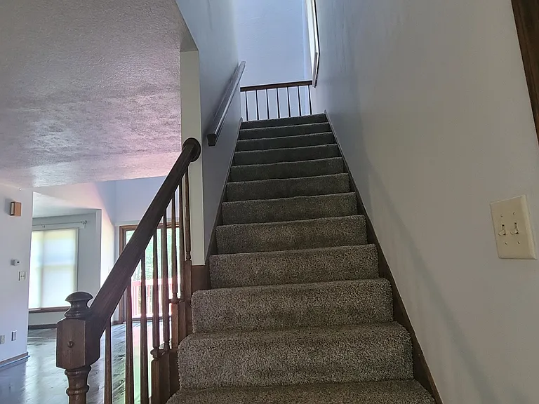 The main entrance offers immediate, convenient access to the attached garage on the right and the staircase leading upstairs.
