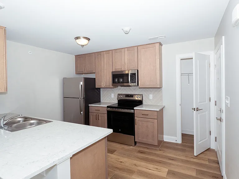 View of range, fridge, and microwave side of kitchen. Features a pantry closet to the right which is located behind your entrance door.