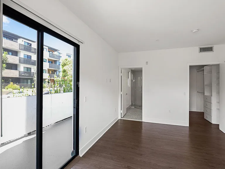 Bedroom with Walk-In Closet with Built-In Organizers and a Bathroom