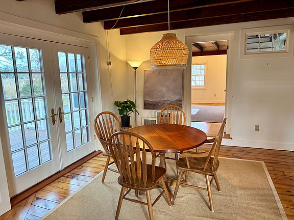 The dining area has a transom window looking up the stairs and French doors opening to the north-facing porch.