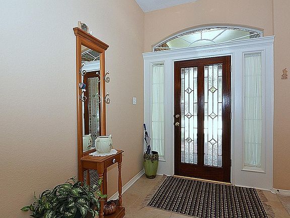 The leaded glass front door opens to a lovely foyer with side lights, an arched transom and soaring 