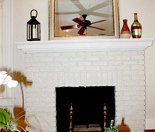 Wood burning fireplace with brick surround and wood mantle.