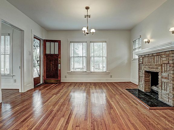 Looking south from the Dining Room into the Living Room. Note beautifully restored original oak floors and original light fixtures.