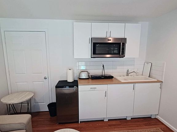 Small but mighty kitchenette with new cabinetry, mini fridge, microwave, toaster, airfryer, electric burners, and stocked with basic essentials.