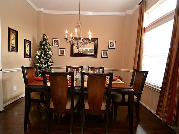 Dining room dazzled by crown molding, chair rails, hardwood laminate floors and access to the kitche