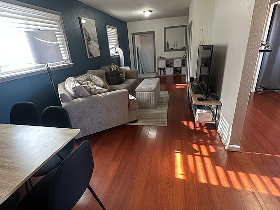 This inviting living space features gleaming hardwood floors and a modern open-concept layout, perfect for entertaining or relaxing after a long day.