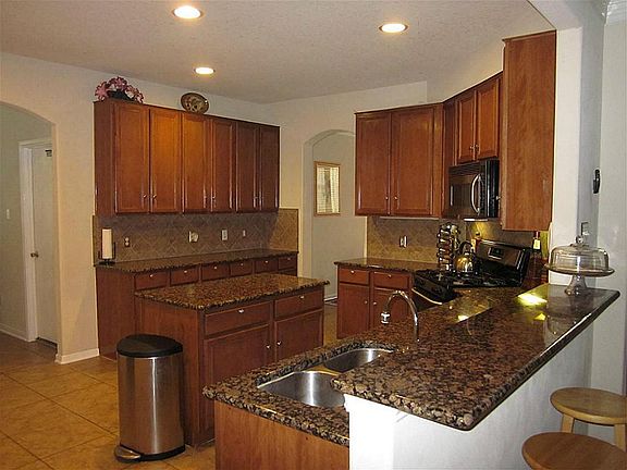 Upgraded recessed lighting, brushed nickel hardware, tile floor, & back splash, large walk in pantry, and large breakfast bar!