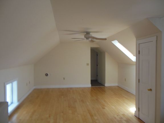 Living room with hardwood floors and skylight