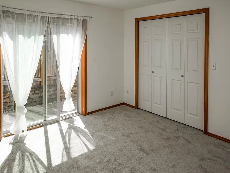 1st Floor _ Private bedroom with direct access to a sunny private brick patio and additional under-stair storage.