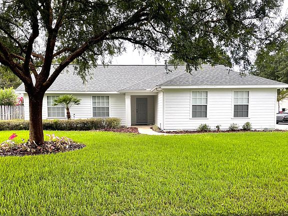 Front View showing large corner lot with beautiful landscaping. Professional lawn service provided by owner.