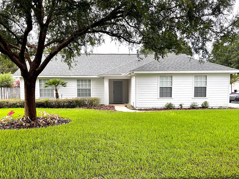 Front View showing large corner lot with beautiful landscaping. Professional lawn service provided by owner.