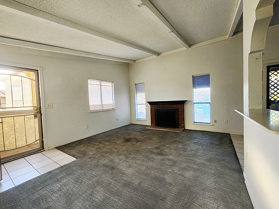 View of family room with security gate at front door and wood burning fireplace