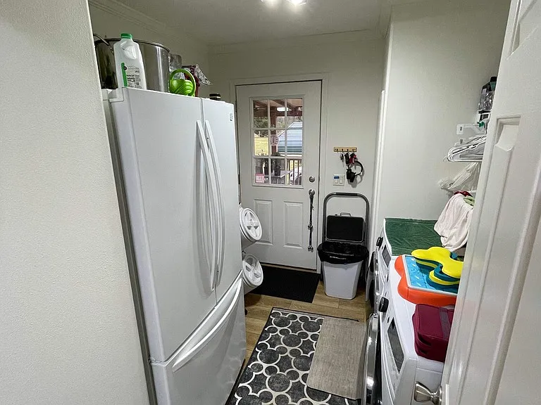 Laundry room with additional back door entrance.