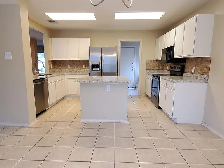 View from eat-in breakfast area looking into the kitchen area. Laundry, pantry, and garage are through the door in the picture