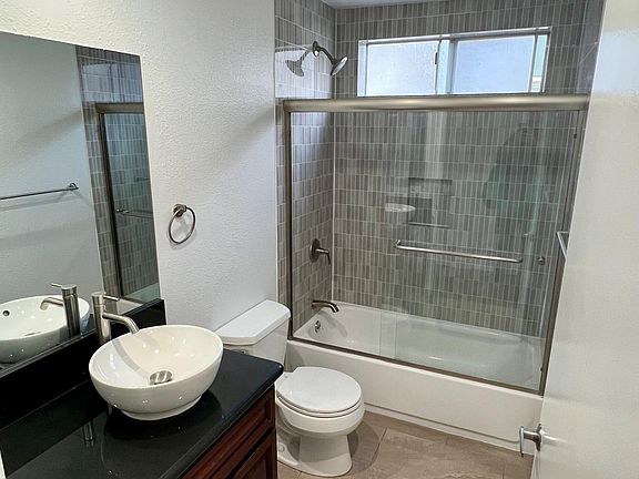 Modern Bathroom with lots of Granite Counter Space, Stone Floors and Full Shower/Tub Enclosure