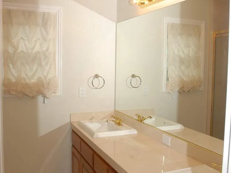 Master Bathroom- features a massive custom mirror and an elegant dual-sink vanity.