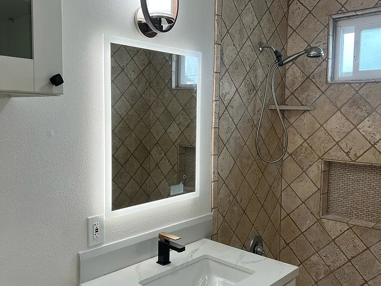 Bathroom with brand new shower head, Brand new Vanity, Faucet, Lighted Mirror, New Light, New cabinet above the New Tall toilet with light, Tiled Shower and Window in bathroom