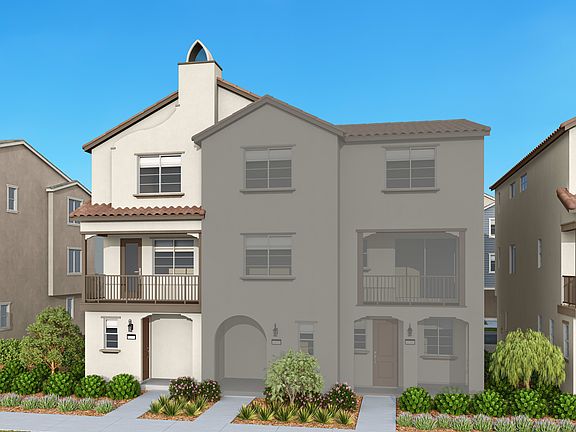 A multi-story residential building with a Mediterranean-style architecture, surrounded by lush green