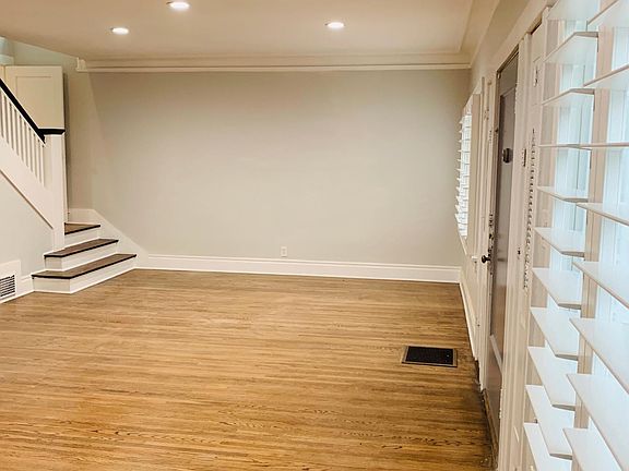 View of large living room with a staircase leading to upstairs or to the kitchen. There are two ways to access the kitchen.