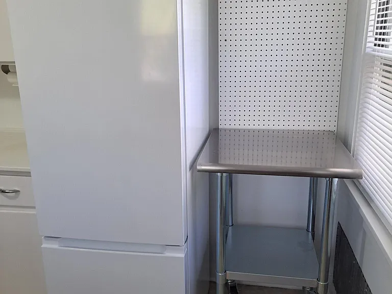Fridge and work restaurant quality work table. Peg board for more storage.