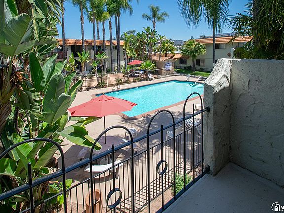 A balcony looking out at swimming pool and bbq area.