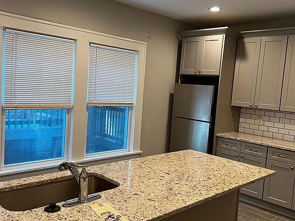 Kitchen with stainless appliances - refrigerator, dishwasher, microwave & stove.