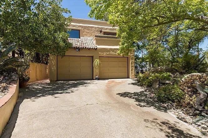 Back driveway provides access to the garage. Walkway on the left leads to the kitchen.