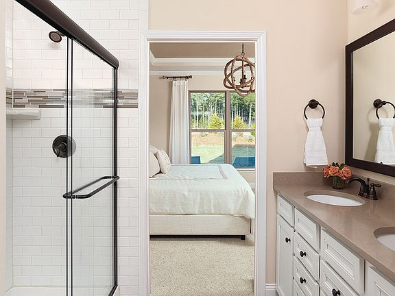 Owner s suite bath with walk-in subway tile shower, white cabinets, double sinks and quartz countert