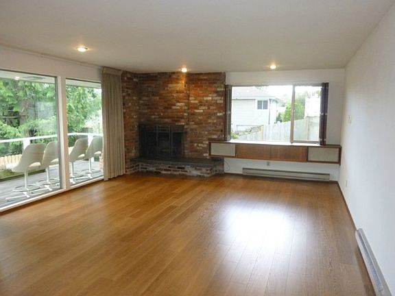 60's added on Recroom with built in book case, raised hearth brick fireplace.
