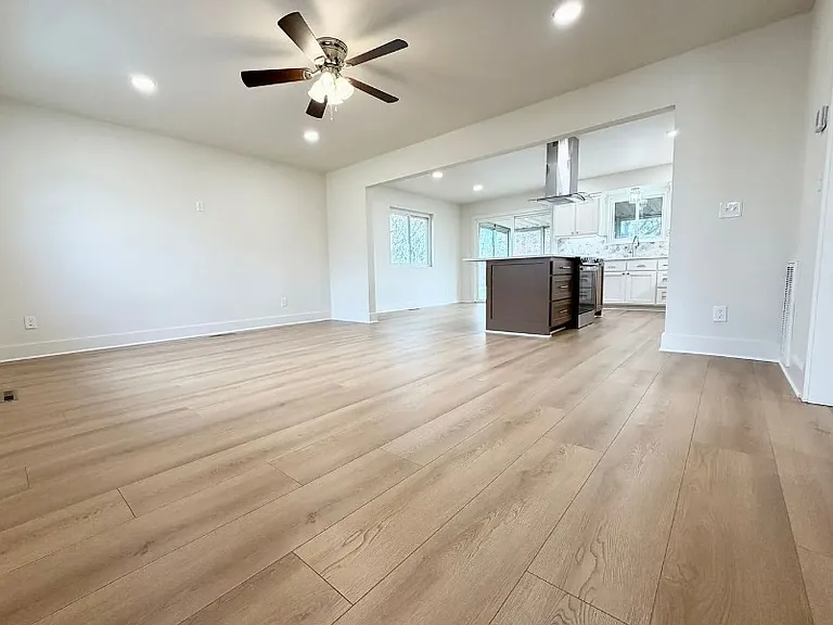 From top of stairs looking across living area to kitchen.